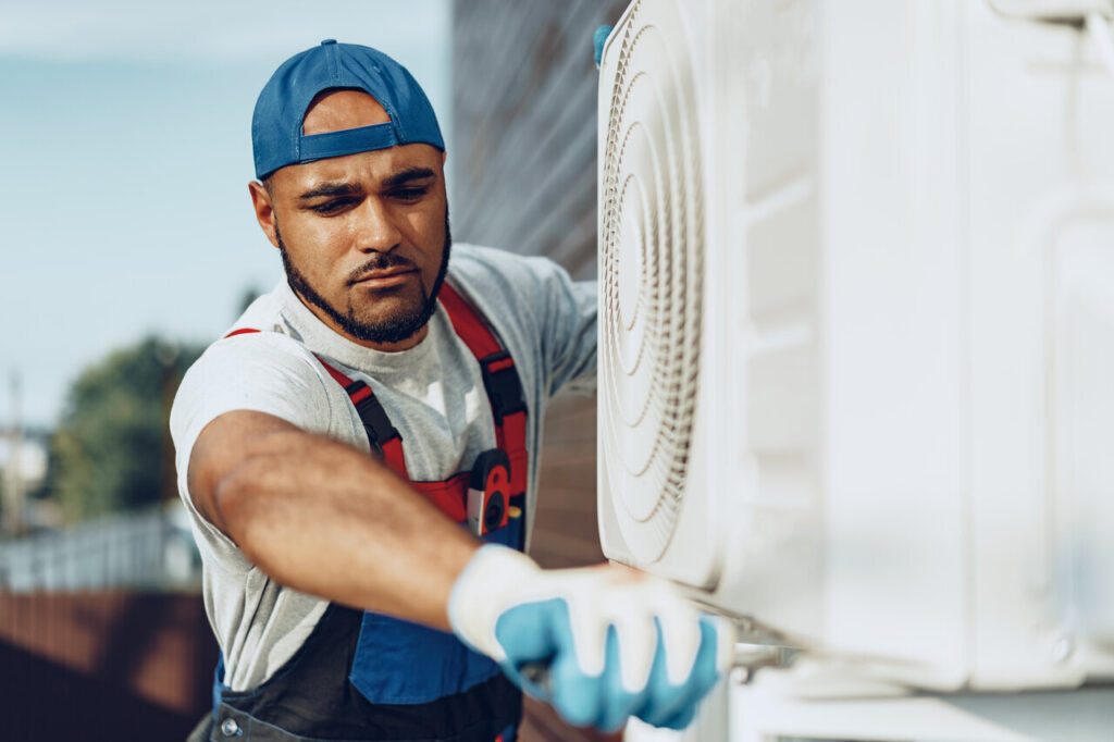 A technician inspecting an air conditioner, focused on ensuring optimal performance and comfort