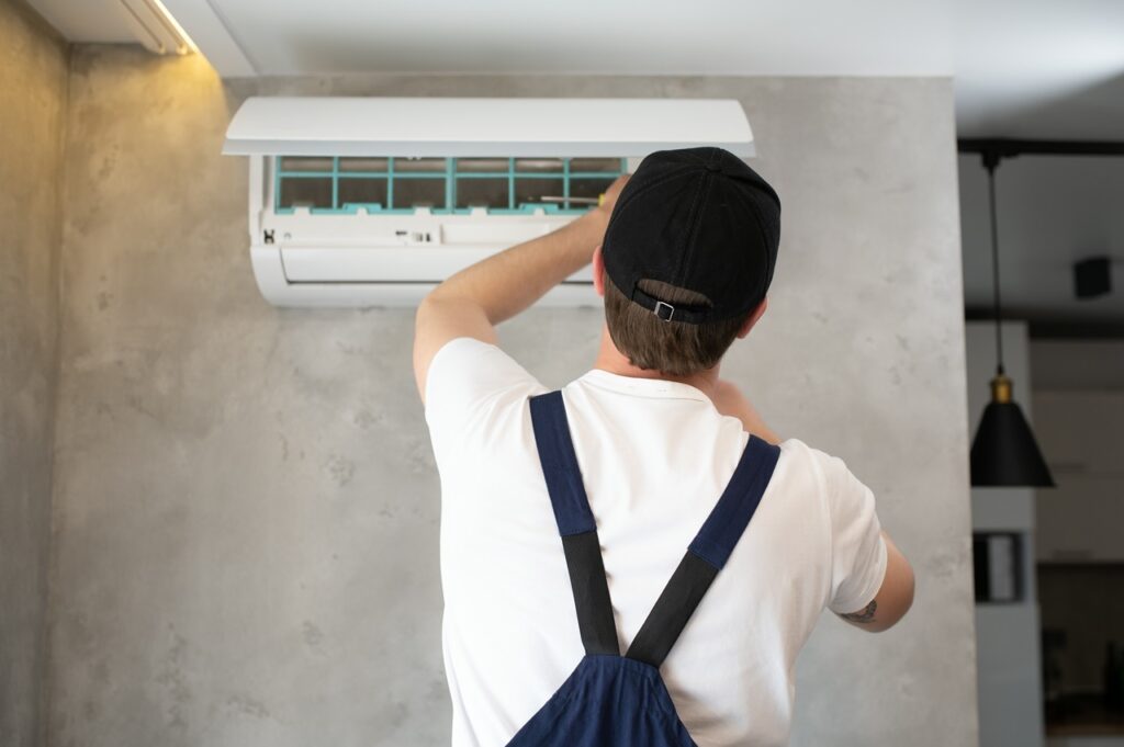 A professional is fixing an air conditioner