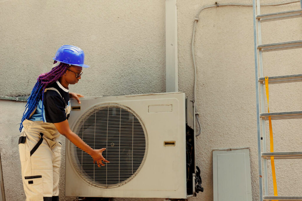 A technician is servicing an air conditioner, concentrating on repairs to enhance cooling efficiency.